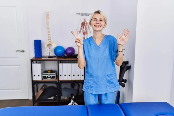 Jovem Fisioterapeuta Mulher Trabalhando Clínica Recuperação Dor Mostrando Apontando Para — Fotografia de Stock