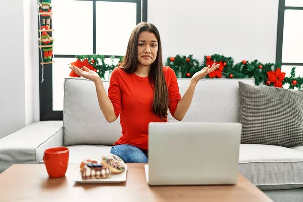Jovem Morena Usando Laptop Sentado Sofá Natal Expressão Indolente Confusa — Fotografia de Stock