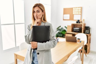 Ofisteki sarışın iş kadını parmakları dudaklarında sessiz olmak istiyor. sessizlik ve gizli konsept. 