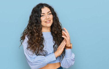 Latin asıllı genç bir kız, günlük giysiler içinde alkışlıyor, alkışlıyor, mutlu ve neşeli, gururlu elleri bir arada. 