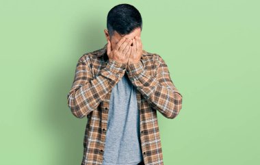 Sakallı, sıradan tişörtlü, suratını elleriyle kapatıp ağlayan İspanyol bir adam. depresyon kavramı. 