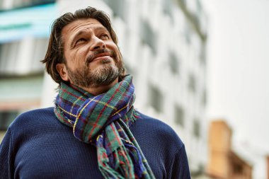 Kasabada gülümseyen orta yaşlı yakışıklı bir adam.