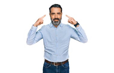 Orta yaşlı, sakallı, iş gömleği giyen, gülümseyen, iki eliyle kafasını gösteren, harika bir fikir ya da düşünce, iyi bir hafıza. 