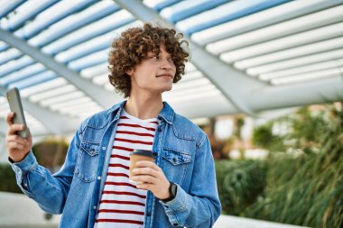 Genç İspanyol adam şehirde akıllı telefon kullanıyor.