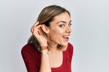 Gündelik kazak giyen, el pençe divan gülümseyen, dedikoduları ve dedikoduları dinleyen genç, beyaz bir kadın. Sağırlık kavramı. 