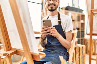 Sanat stüdyosunda akıllı telefon çizimi yapan genç bir İspanyol sanatçı..