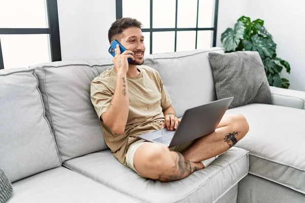 Jovem Hispânico Usando Laptop Falando Telefone Casa — Fotografia de Stock