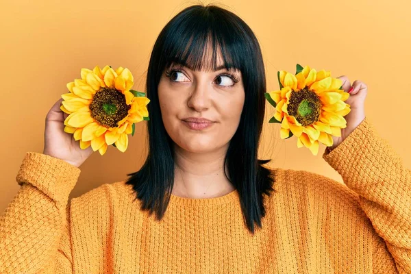 Mujer Hispana Joven Sosteniendo Girasoles Sobre Los Ojos Sonriendo Mirando — Foto de Stock