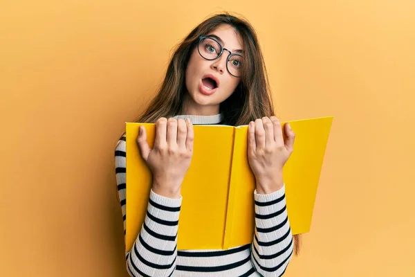 Young Caucasian Woman Reading Book Wearing Glasses Afraid Shocked Surprise — Stock Photo, Image