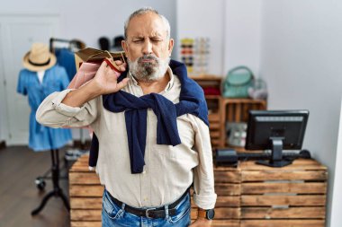 Butik dükkanında alışveriş torbaları tutan yakışıklı bir adam. Depresyonda ve üzüntüden ağlıyor, ağlıyor ve korkuyor. hüzünlü ifade. 