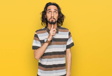 Gündelik kıyafetler giyen genç İspanyol adam şüphe üzerine yoğunlaşmıştı. Parmakları çenesinde ve yukarı bakıyordu. 