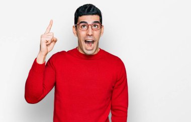 Gündelik kıyafetler giyen ve gözlük takan yakışıklı İspanyol adam başarılı bir fikri işaret ediyor. Heyecanlı ve mutlu. Bir numara.. 