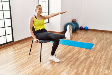 Genç sarışın kız gülümsüyor. Spor merkezinde mutlu antrenmanlar..