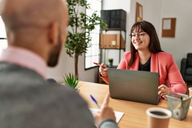 Ofiste çalışırken gülümseyen iki İspanyol iş adamı..