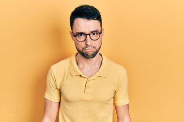 Gündelik kıyafetler ve gözlük takan genç İspanyol adam üzgün ve endişeli, sinirli ve korkmuş. hüzünlü ifade. 