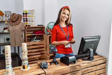 Kafkasyalı genç bir esnaf dükkanında elinde dolarlarla mutlu bir şekilde gülümsüyor..