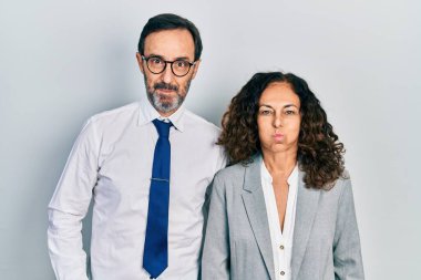 Orta yaşlı bir çift İspanyol kadın ve ofis üniforması giyen komik yüzlü yanakları şişiren bir adam. Havayla şişmiş ağız, çılgın bir ifade.. 