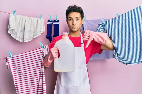 Hombre Hispano Guapo Lavando Ropa Sosteniendo Botella Detergente Con Cara — Foto de Stock