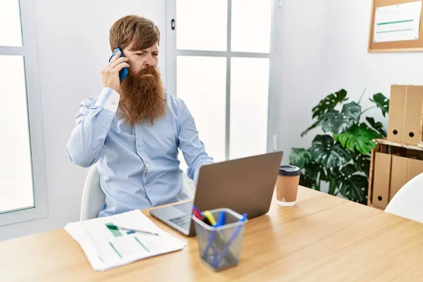 事務所のスマートフォンで真剣な表情で話す若いアイルランド人ビジネスマン — ストック写真