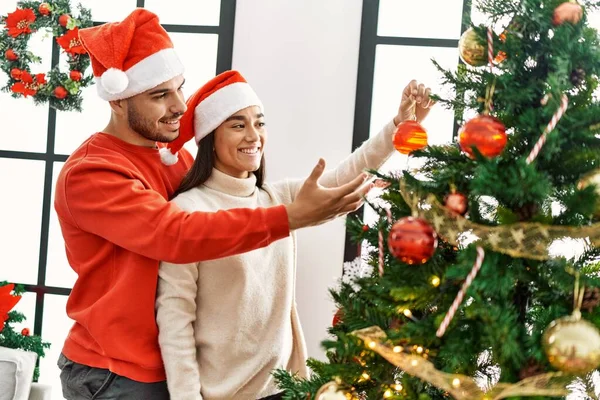 Genç Spanyol Çift Gülümsüyor Mutlu Noel Ağacı Süslüyor Evde — Stok fotoğraf