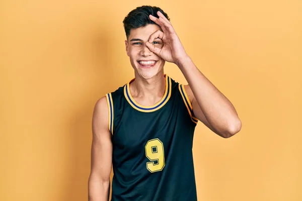 身穿篮球服的年轻人面带微笑地做着一个手势 用手指看着他 脸上洋溢着欢乐的表情 — 图库照片