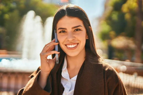 若いヒスパニック系の女性は 市内のスマートフォンで幸せな話を笑って — ストック写真