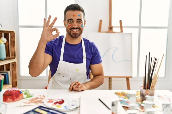 年轻的他的恐慌男子 胡子在艺术工作室与画的脸微笑积极做好手势手和手指 成功表达 — 图库照片