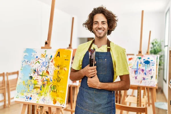 Joven Artista Hispano Sonriendo Feliz Sosteniendo Pinceles Estudio Arte — Foto de Stock