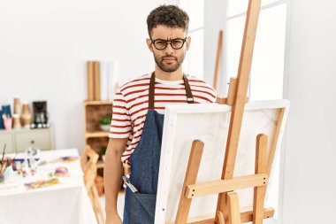 Sanat stüdyosundaki Arap genç adam yüzünde ciddi bir ifadeyle rahatladı. Basit ve doğal bir şekilde kameraya bakıyorsun.. 