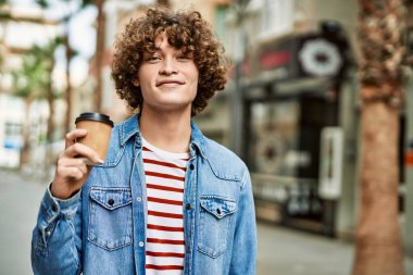 Genç İspanyol adam şehirde bir fincan kahve içiyor.