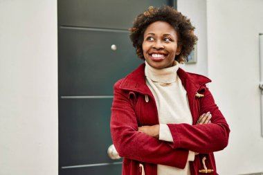 Güzel bir iş adamı Afro saçlı Amerikalı kadın şehirde mutlu ve kendinden emin bir şekilde gülümsüyor.