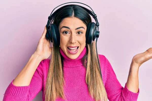 Νεαρή Ισπανόφωνη Γυναίκα Που Ακούει Μουσική Χρησιμοποιώντας Ακουστικά Γιορτάζοντας Επίτευγμα — Φωτογραφία Αρχείου