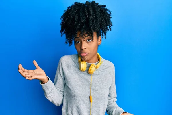 Afroamerikanerin Mit Afro Haaren Sweatshirt Und Kopfhörern Ahnungslos Und Verwirrt — Stockfoto