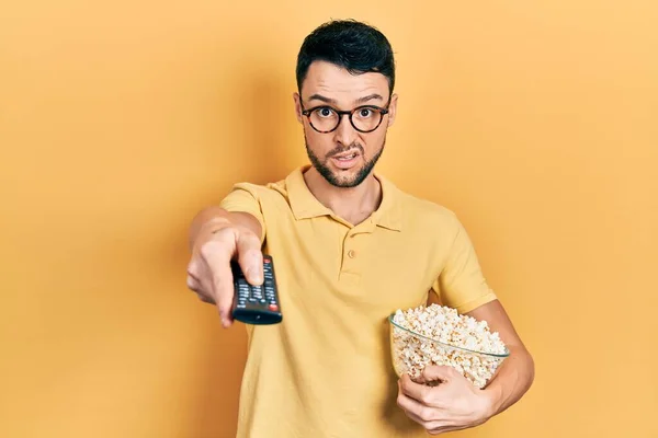Junger Hispanischer Mann Isst Popcorn Mit Kontrolle Schockgesicht Sieht Skeptisch — Stockfoto