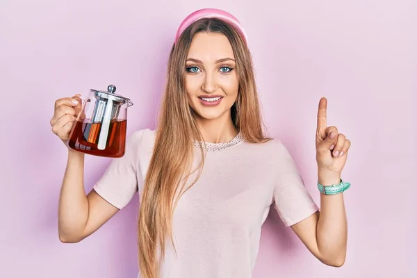 Jovem Loira Segurando Jarra Chá Sorrindo Com Uma Ideia Pergunta — Fotografia de Stock