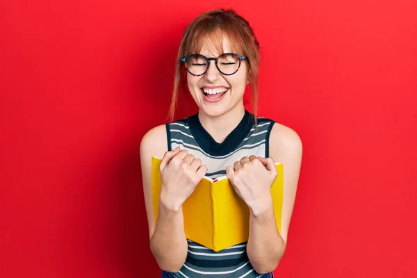 Kızıl Saçlı Genç Kadın Kitap Okuyor Gözlük Takıyor Çılgınca Kutlama — Stok fotoğraf