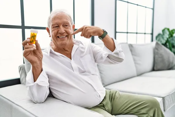 Uomo Anziano Possesso Pillole Sorridente Allegro Mostrando Indicando Con Denti — Foto Stock