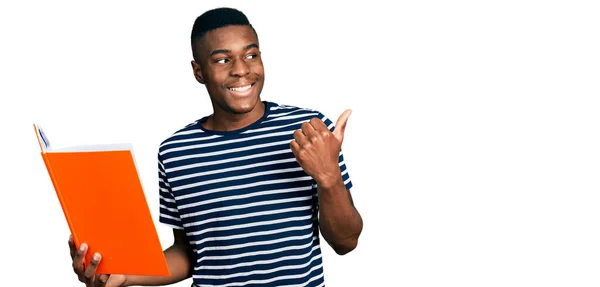 Jeune Homme Afro Américain Tenant Livre Pointant Pouce Vers Côté — Photo