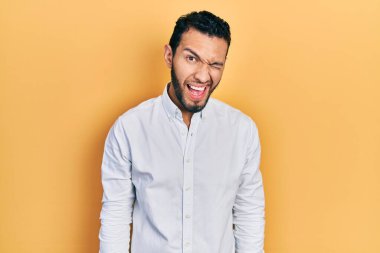 Sakallı, iş gömleği giyen, kameraya seksi bir ifadeyle bakan, neşeli ve mutlu yüzlü bir İspanyol.. 