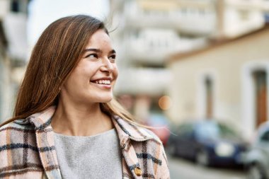 Sokakta kendinden emin gülümseyen genç sarışın kadın
