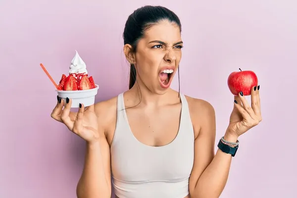 Junge Hispanische Frau Sportkleidung Mit Apfel Und Eis Der Hand — Stockfoto