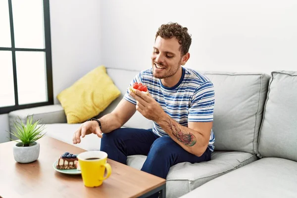 Genç İspanyol adam evde kahvaltı ederken kendine güveniyor.