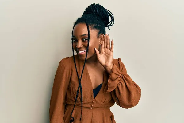 拥有辫子的非洲裔美国女人 身穿休闲的棕色衬衫 双手相对地微笑 聆听谣言或流言蜚语 聋的概念 — 图库照片