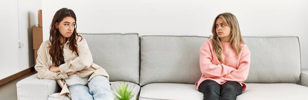 Молодая пара злится сидя дома на диване в тишине.