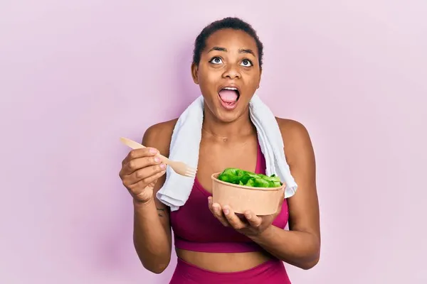 Chica Afroamericana Joven Usando Ropa Deportiva Comiendo Ensalada Enojada Loca —  Fotos de Stock