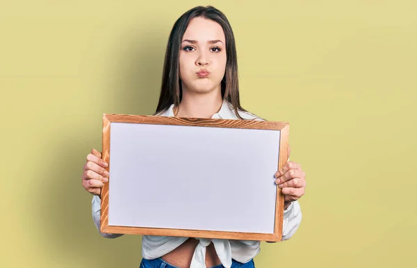 Young Hispanic Woman Holding Empty White Chalkboard Puffing Cheeks Funny — Stock Photo, Image