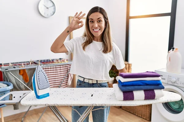 Çamaşır Odasında Giysilerini Ütüleyen Genç Spanyol Kadın Gülümsüyor Parmaklarıyla Tamam — Stok fotoğraf