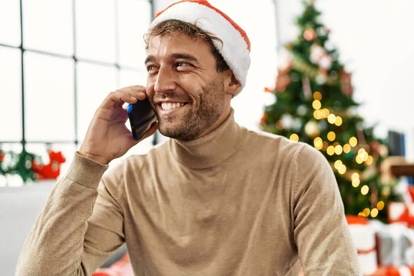 Νεαρός Ισπανόφωνος Μιλάει Στο Smartphone Κάθεται Δίπλα Στο Χριστουγεννιάτικο Δέντρο — Φωτογραφία Αρχείου