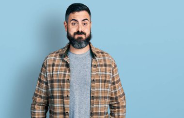 Sakallı, sıradan tişörtlü, komik yüzlü İspanyol bir adam. Havayla şişmiş ağız, çılgın bir ifade.. 