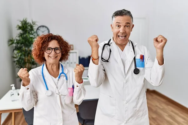 Dois Médicos Meia Idade Clínica Médica Gritando Orgulhosos Celebrando Vitória — Fotografia de Stock